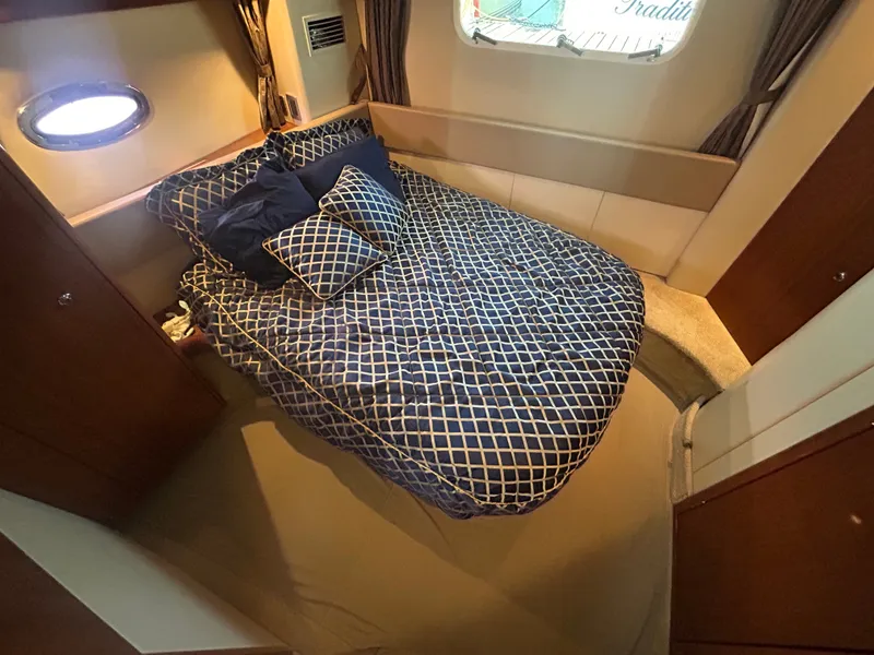 Slide: The Image of The cabin of a 2007 Meridian 368 Motoryacht features a cozy bed with patterned pillows. - 23