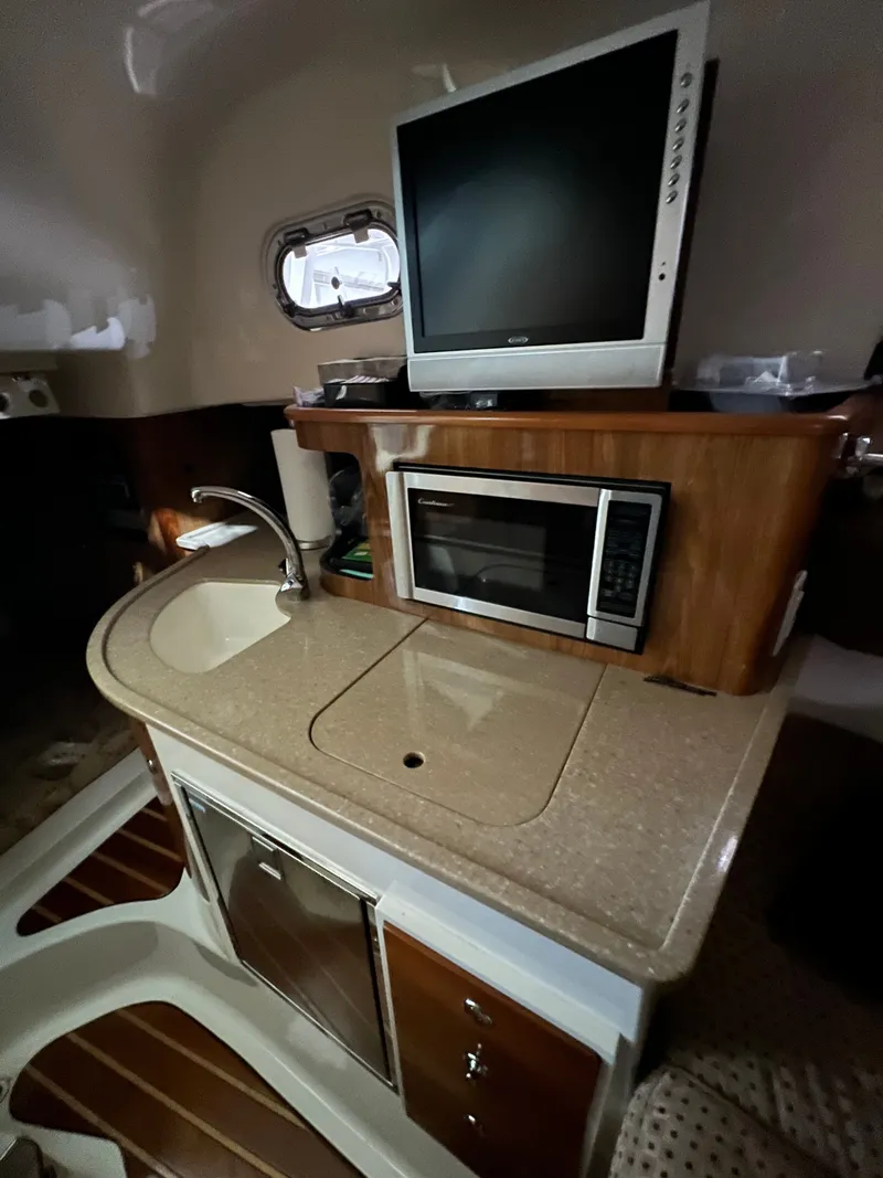 Slide: The Image of Interior of 2008 Pursuit OS 315 Offshore with kitchenette and TV. - 7