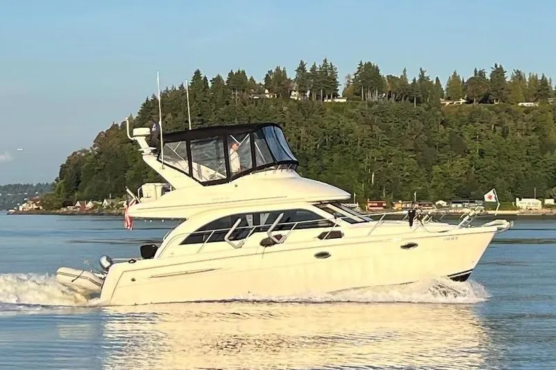 The Image of 2004 Meridian 341 Sedan cruising on a serene lake with lush green shoreline. - 1