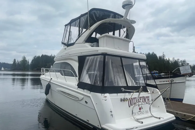 Slide: The Image of 2004 Meridian 341 Sedan yacht docked on a calm lake with forested shoreline. - 3