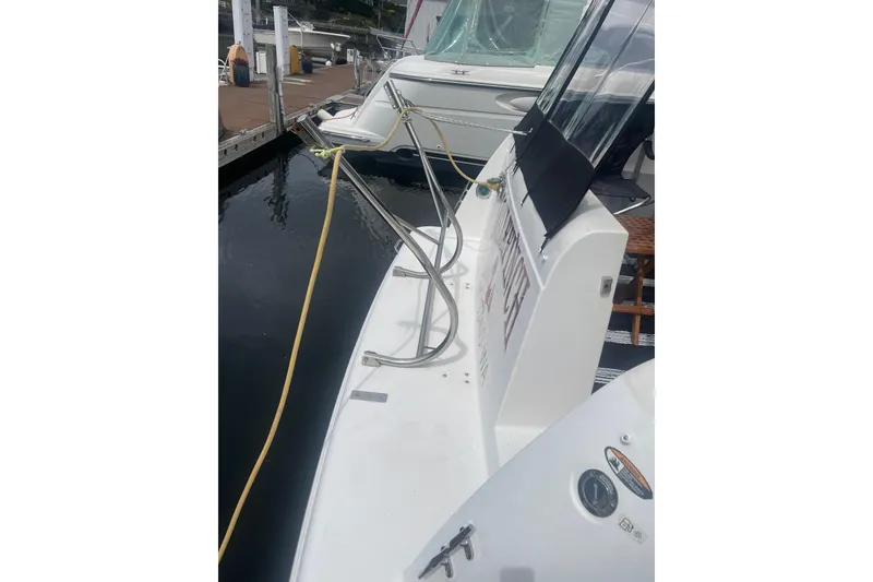 Slide: The Image of 2004 Meridian 341 Sedan yacht docked, showing rear deck and mooring lines. - 32