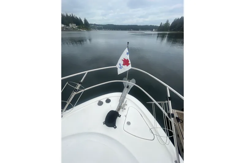 Slide: The Image of Bow view of 2004 Meridian 341 Sedan yacht on calm waters with scenic shoreline. - 34