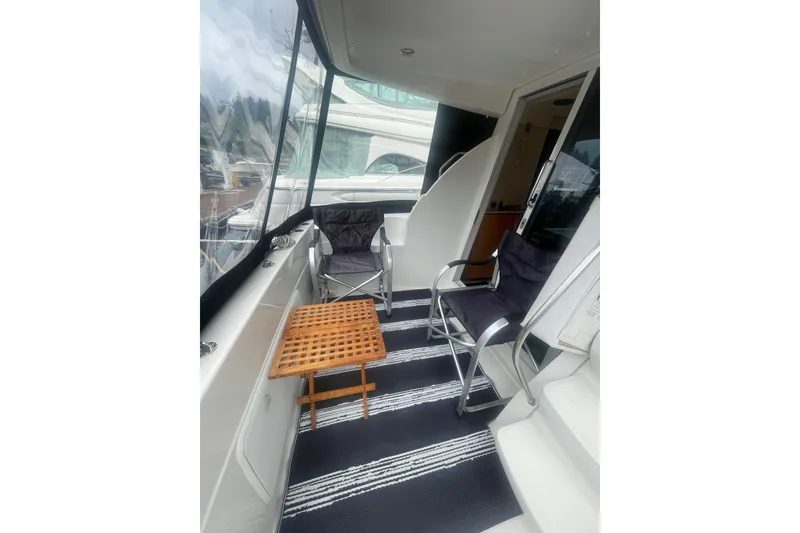 Slide: The Image of 2004 Meridian 341 Sedan yacht deck with chairs and table, featuring a sleek design. - 5