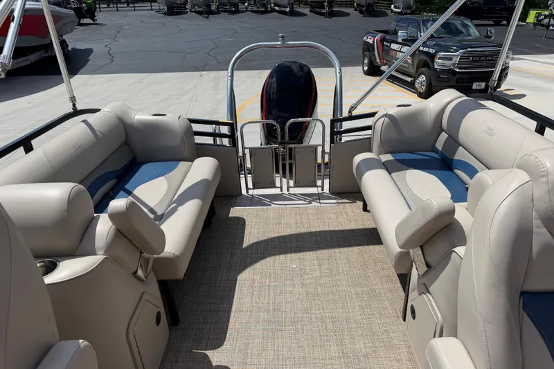 Slide: The Image of 2018 JC 25 Neptoon DSL pontoon boat interior with beige seating and blue accents. - 20