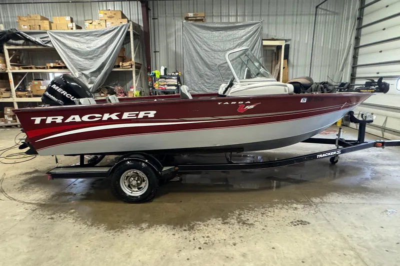 The Image of 2011 Tracker Targa V-18 Combo boat on trailer in a garage setting. - 0