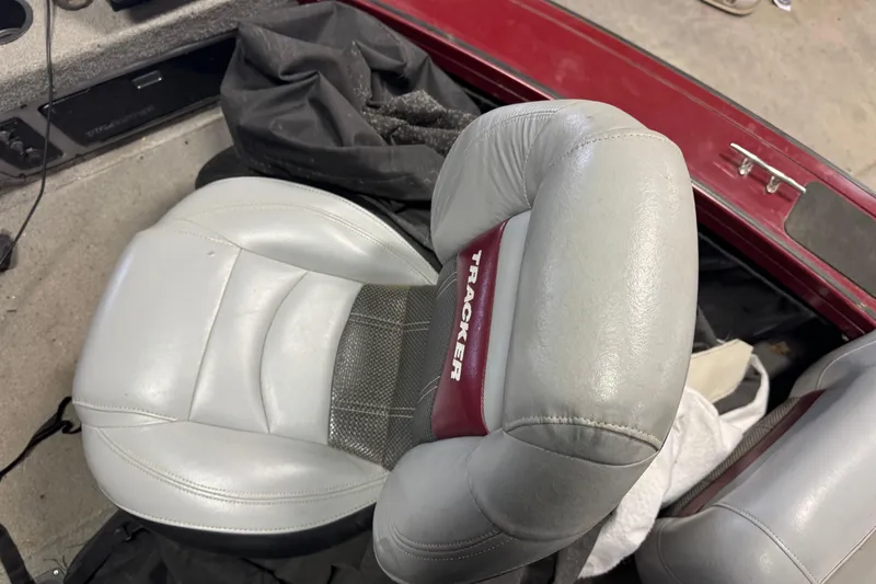 Slide: The Image of 2011 Tracker Targa V-18 Combo boat seat, gray with red accents, in a red interior. - 13