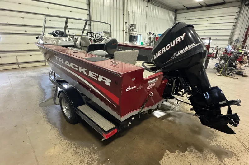 Slide: The Image of 2011 Tracker Targa V-18 Combo boat with Mercury OptiMax engine in a garage. - 4