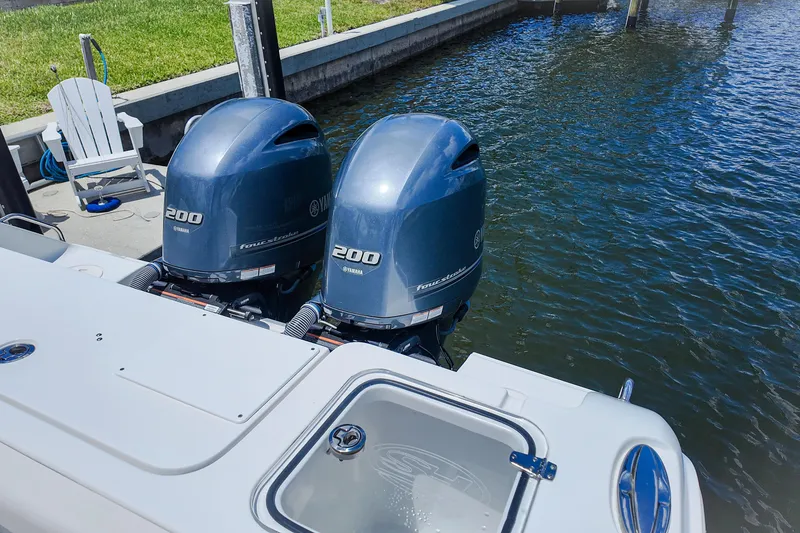 Slide: The Image of Twin Yamaha outboard engines on a 2022 Sea Hunt Gamefish 27 boat docked by water. - 20