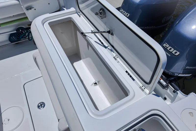 Slide: The Image of 2022 Sea Hunt Gamefish 27 boat with open storage compartment and dual Yamaha engines. - 22