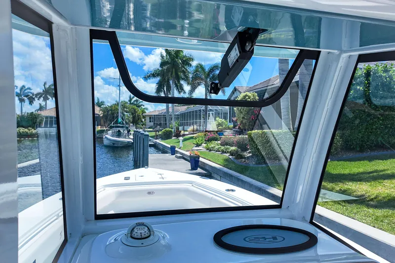 Slide: The Image of 2022 Sea Hunt Gamefish 27 boat interior view with canal and palm trees. - 27