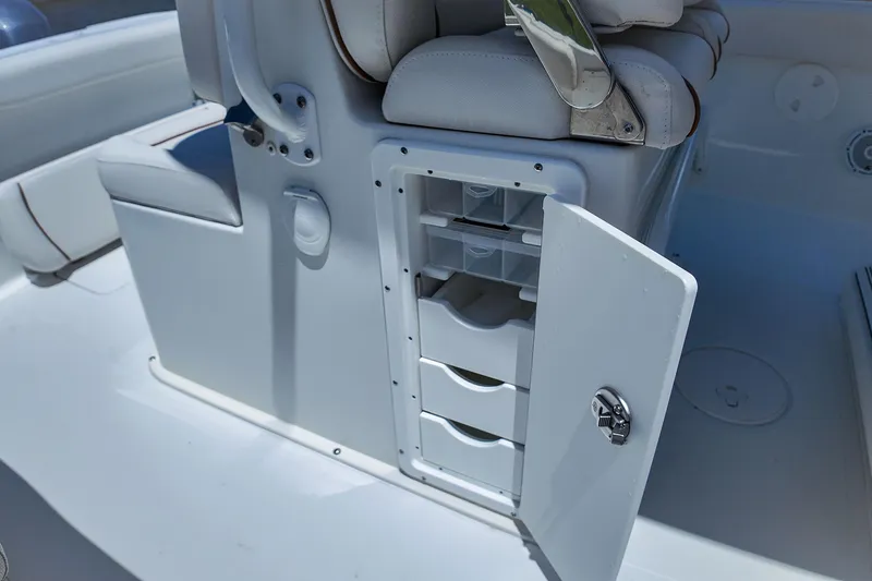 Slide: The Image of 2022 Sea Hunt Gamefish 27 boat storage compartment with open door and drawers. - 28