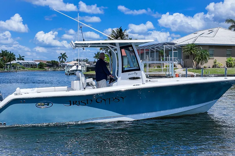 Slide: The Image of 2022 Sea Hunt Gamefish 27 boat on water, sunny day, residential waterfront background. - 3