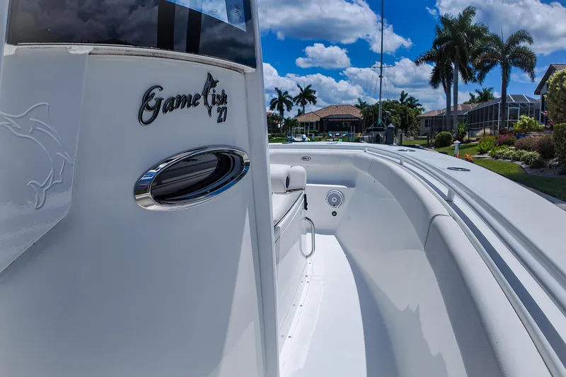 Slide: The Image of 2022 Sea Hunt Gamefish 27 boat, sleek design, sunny day, palm trees in background. - 32