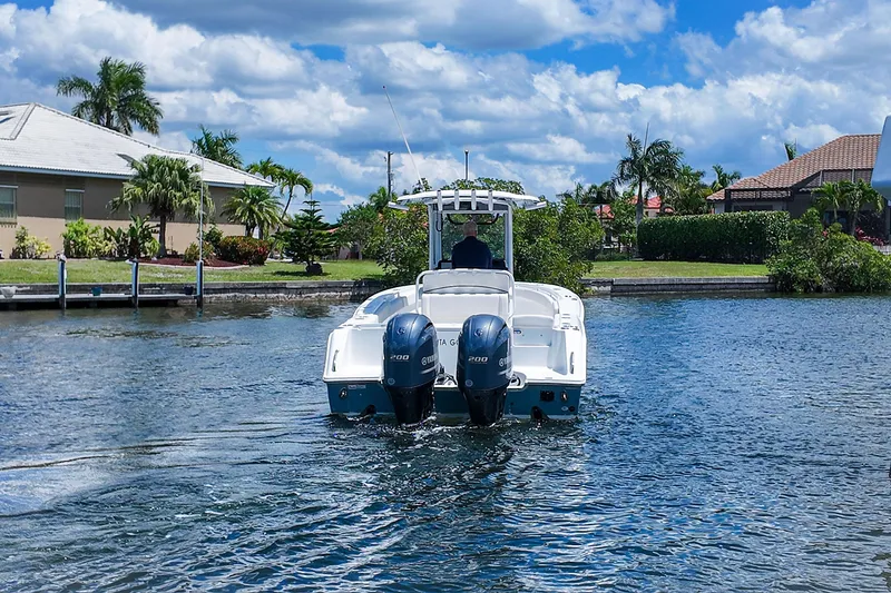 Slide: The Image of 2022 Sea Hunt Gamefish 27 boat cruising on a sunny day in a residential canal. - 6