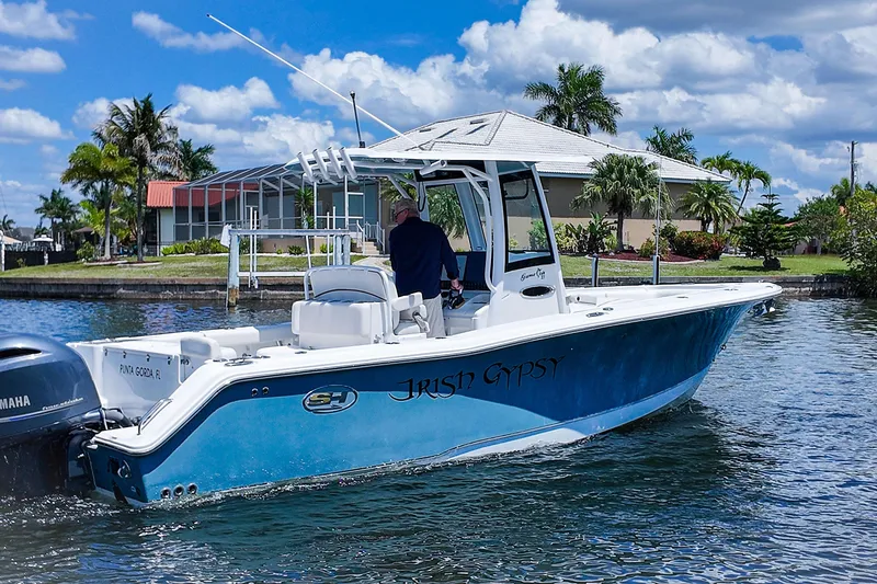 Slide: The Image of 2022 Sea Hunt Gamefish 27 boat on water, blue hull, tropical background. - 5