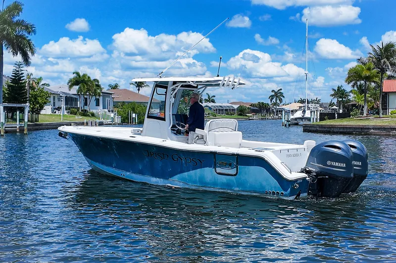Slide: The Image of 2022 Sea Hunt Gamefish 27 boat on a sunny canal with palm trees. - 7