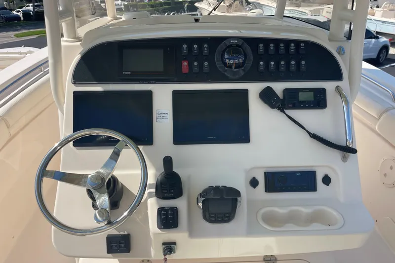 Slide: The Image of Control panel of a 2018 Grady-White Canyon 306 boat with steering wheel and navigation equipment. - 7