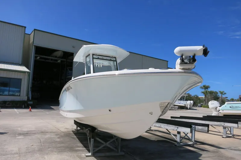 Slide: The Image of 2022 Robalo 266 Cayman boat displayed outside a storage facility under clear blue skies. - 10