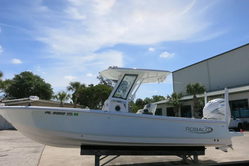 Slide: The Image of 2022 Robalo 266 Cayman boat displayed outdoors under a clear blue sky. - 13