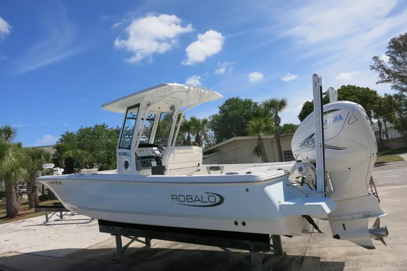 Slide: The Image of 2022 Robalo 266 Cayman boat with Yamaha engine, parked outdoors under blue sky. - 14