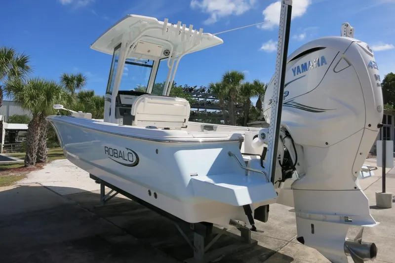 Slide: The Image of 2022 Robalo 266 Cayman boat with Yamaha engine, parked outdoors under a clear blue sky. - 15