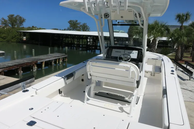 Slide: The Image of 2022 Robalo 266 Cayman boat interior with helm, dockside view, and palm trees. - 17