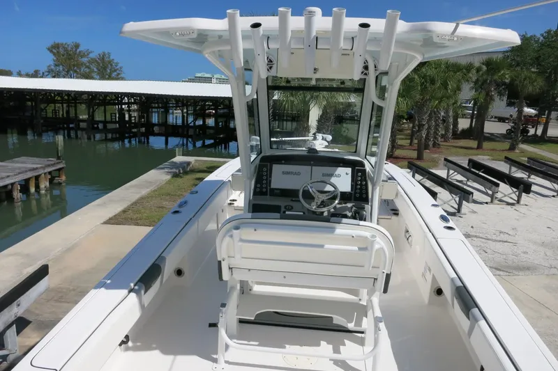 Slide: The Image of 2022 Robalo 266 Cayman boat interior with helm, docked near waterfront. - 18