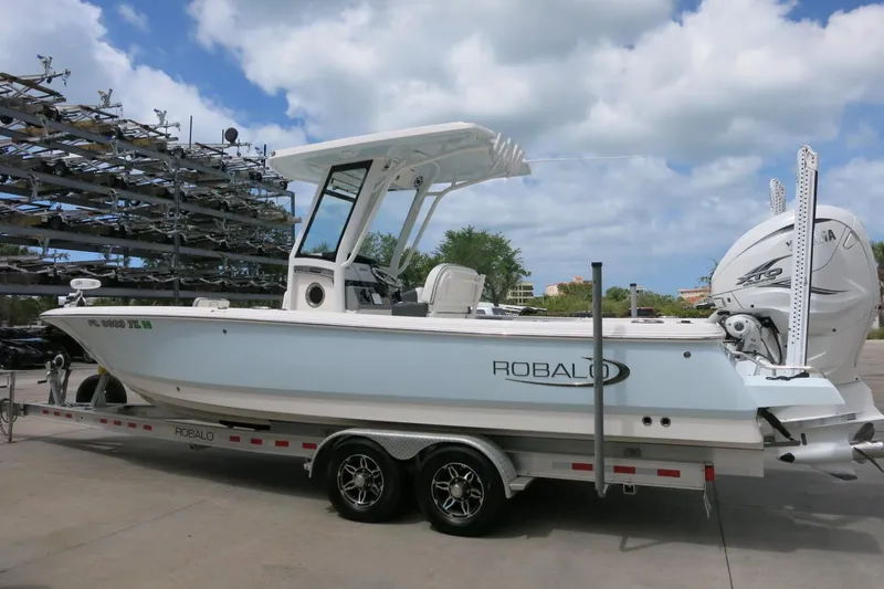 Slide: The Image of 2022 Robalo 266 Cayman boat on trailer under cloudy sky. - 2