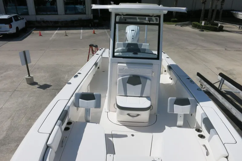 Slide: The Image of 2022 Robalo 266 Cayman boat interior with seating and console, parked in a lot. - 23
