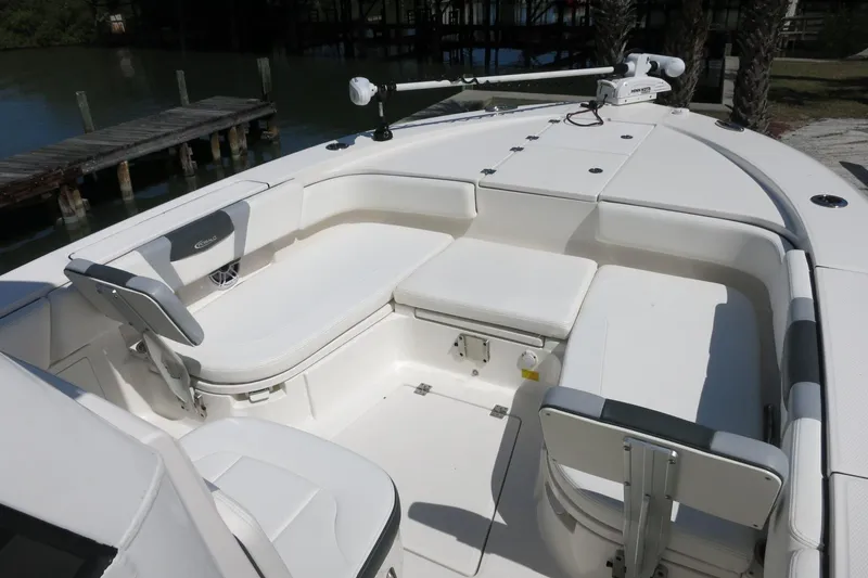 Slide: The Image of 2022 Robalo 266 Cayman boat interior with white seating and storage compartments. - 26