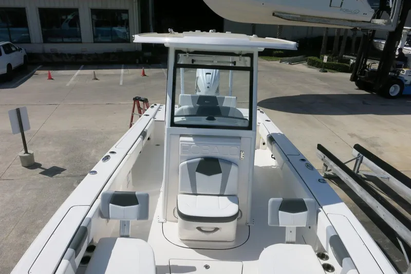 Slide: The Image of 2022 Robalo 266 Cayman boat interior with seating and console, parked on concrete. - 28