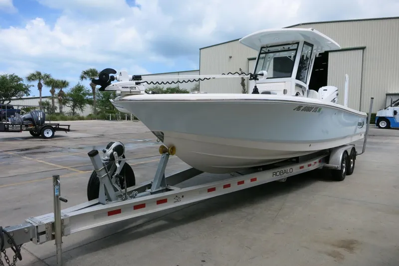 Slide: The Image of 2022 Robalo 266 Cayman boat on trailer, parked outdoors near industrial building. - 3