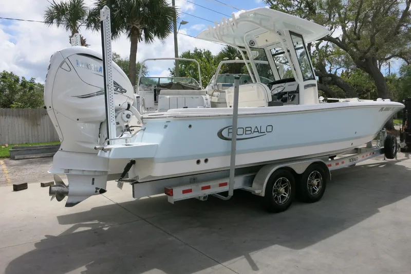 Slide: The Image of 2022 Robalo 266 Cayman boat on trailer, featuring dual engines and sleek design. - 5