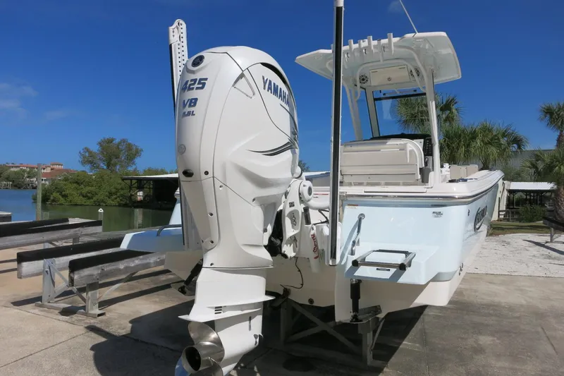 Slide: The Image of 2022 Robalo 266 Cayman boat with Yamaha V8 engine, docked near a scenic waterfront. - 8