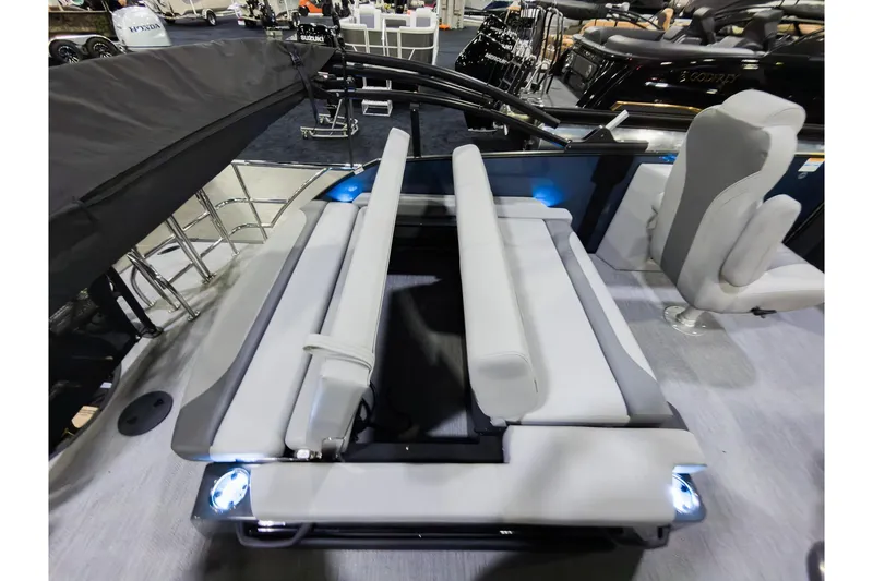 Slide: The Image of 2026 Godfrey Monaco 235 boat with single flip lounge seating, showcased indoors. - 23