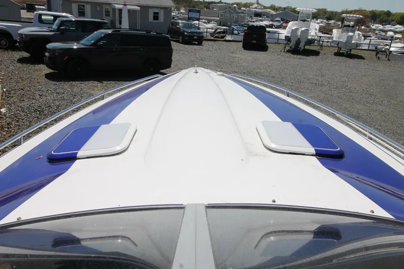 Slide: The Image of 2006 Formula 292 FASTech boat with blue and white deck, parked in a marina. - 3