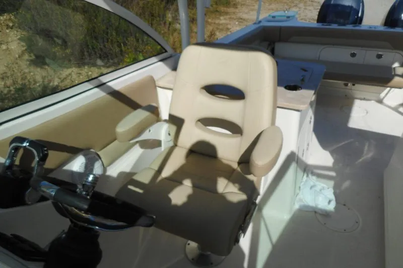 Slide: The Image of Interior of 2020 Sailfish 275 DC boat featuring a beige captain's chair and steering wheel. - 9