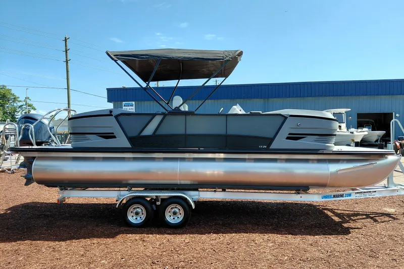 Slide: The Image of 2026 Starcraft VX 24 Q DH pontoon boat on trailer, with canopy, in outdoor setting. - 10