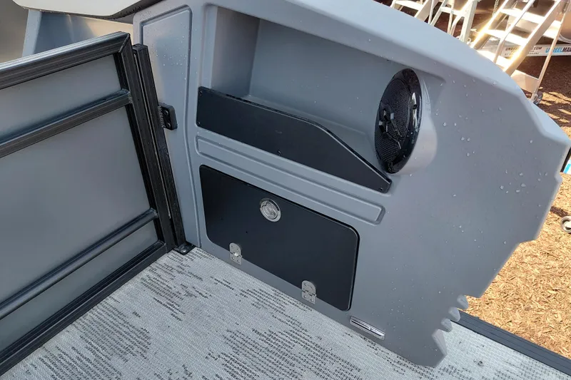 Slide: The Image of Interior of 2026 Starcraft VX 24 Q DH boat, featuring storage compartment and speaker. - 33