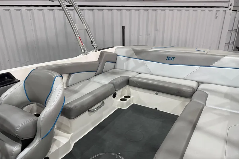 Slide: The Image of 2017 MasterCraft NXT22 boat interior with gray seating and blue accents. - 11