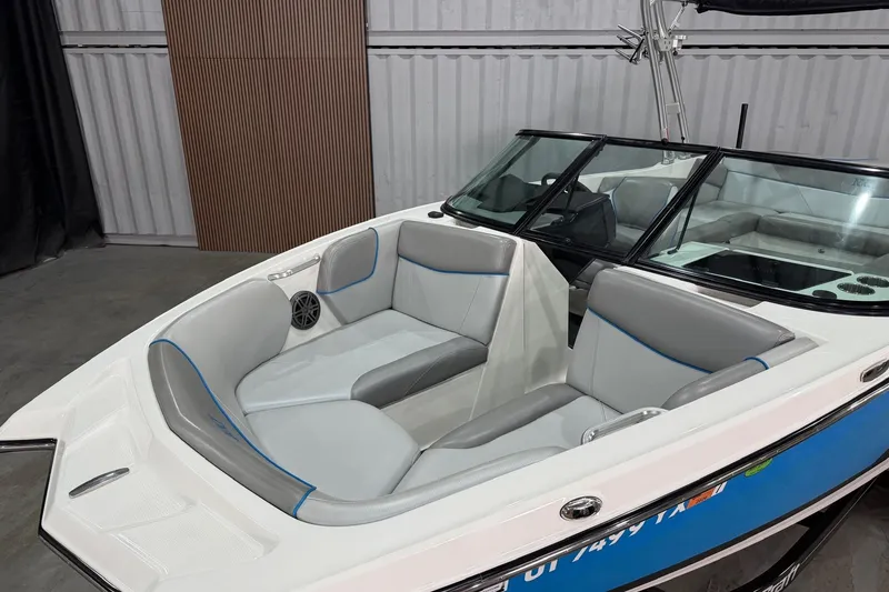 Slide: The Image of 2017 MasterCraft NXT22 boat interior with gray and blue seating, docked indoors. - 4
