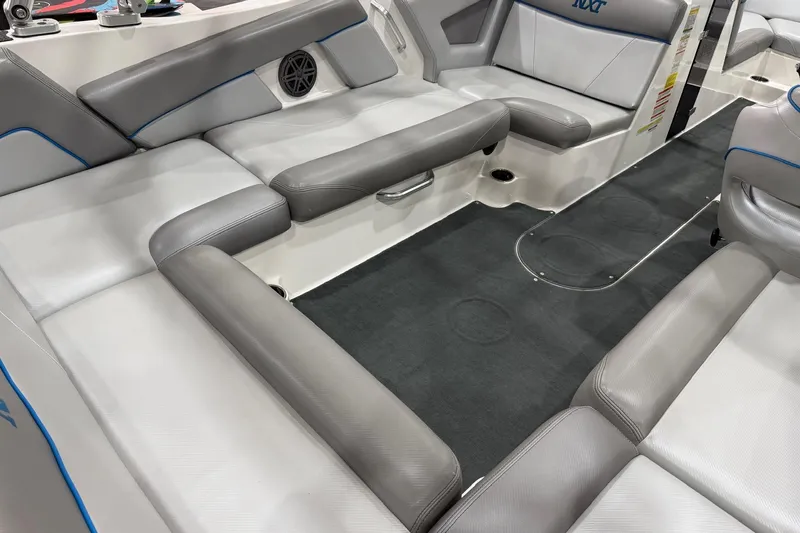 Slide: The Image of 2017 MasterCraft NXT22 boat interior with gray seating and black carpet. - 7
