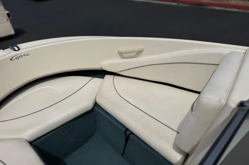 Slide: The Image of Interior seating of a 2000 Bayliner 2150 Capri boat, featuring white upholstery. - 10