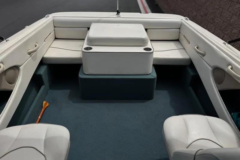 Slide: The Image of Interior of a 2000 Bayliner 2150 Capri boat with white seating and blue carpet. - 12