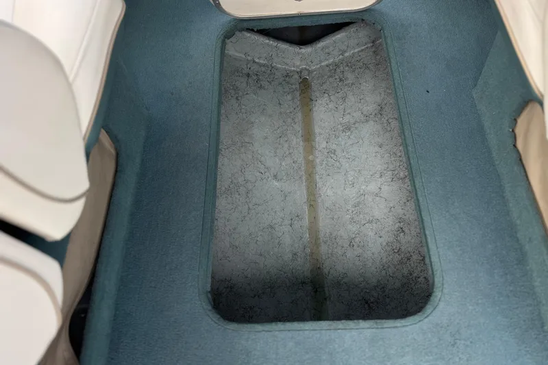 Slide: The Image of Interior view of a 2000 Bayliner 2150 Capri boat with blue carpeted flooring. - 18