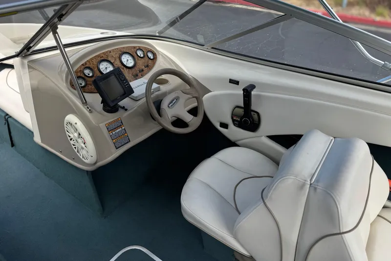 Slide: The Image of Interior of a 2000 Bayliner 2150 Capri boat, featuring steering wheel and dashboard controls. - 20