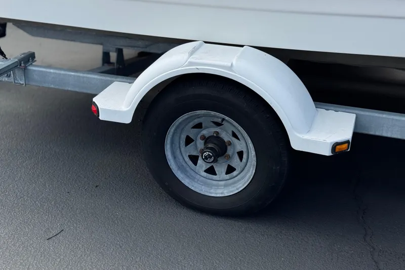 Slide: The Image of Trailer wheel of a 2000 Bayliner 2150 Capri boat on pavement. - 23