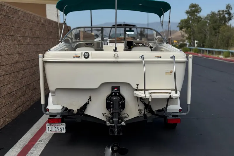 Slide: The Image of Rear view of a 2000 Bayliner 2150 Capri boat with a green canopy. - 4