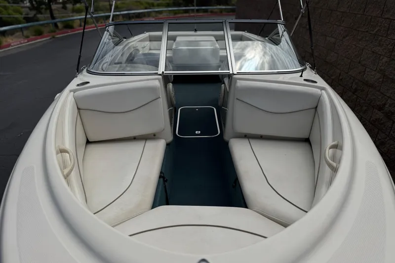 Slide: The Image of 2000 Bayliner 2150 Capri boat with white seating and blue flooring. - 7