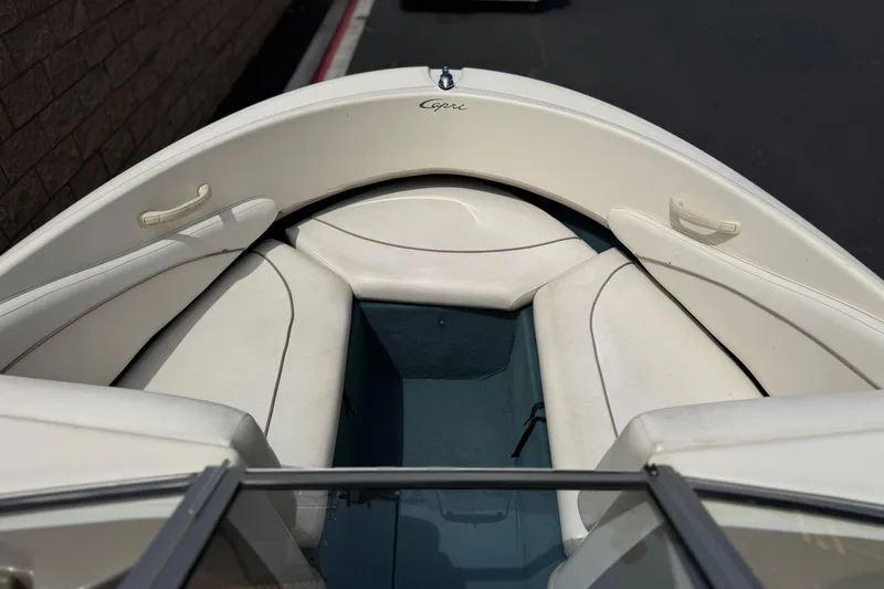 Slide: The Image of 2000 Bayliner 2150 Capri boat interior with white seating and blue flooring. - 8